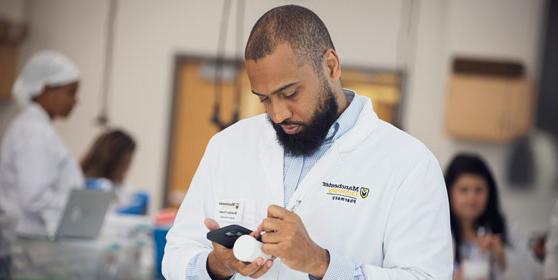 A student creates a label in the pharmacy lab